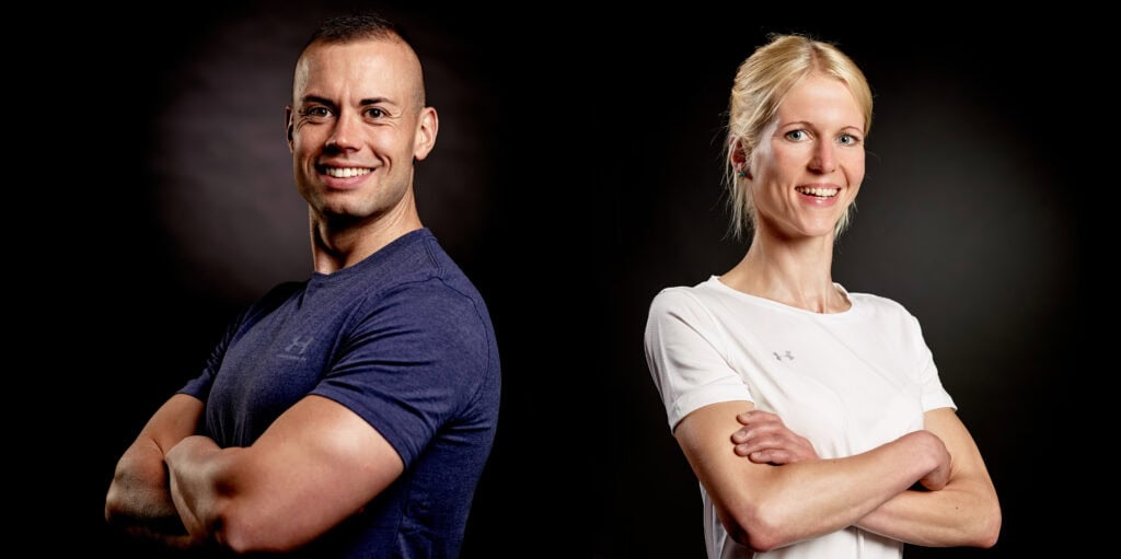 Olaf Henning und Kathy Syring stehen nebeneinander vor einem dunklen Hintergrund.