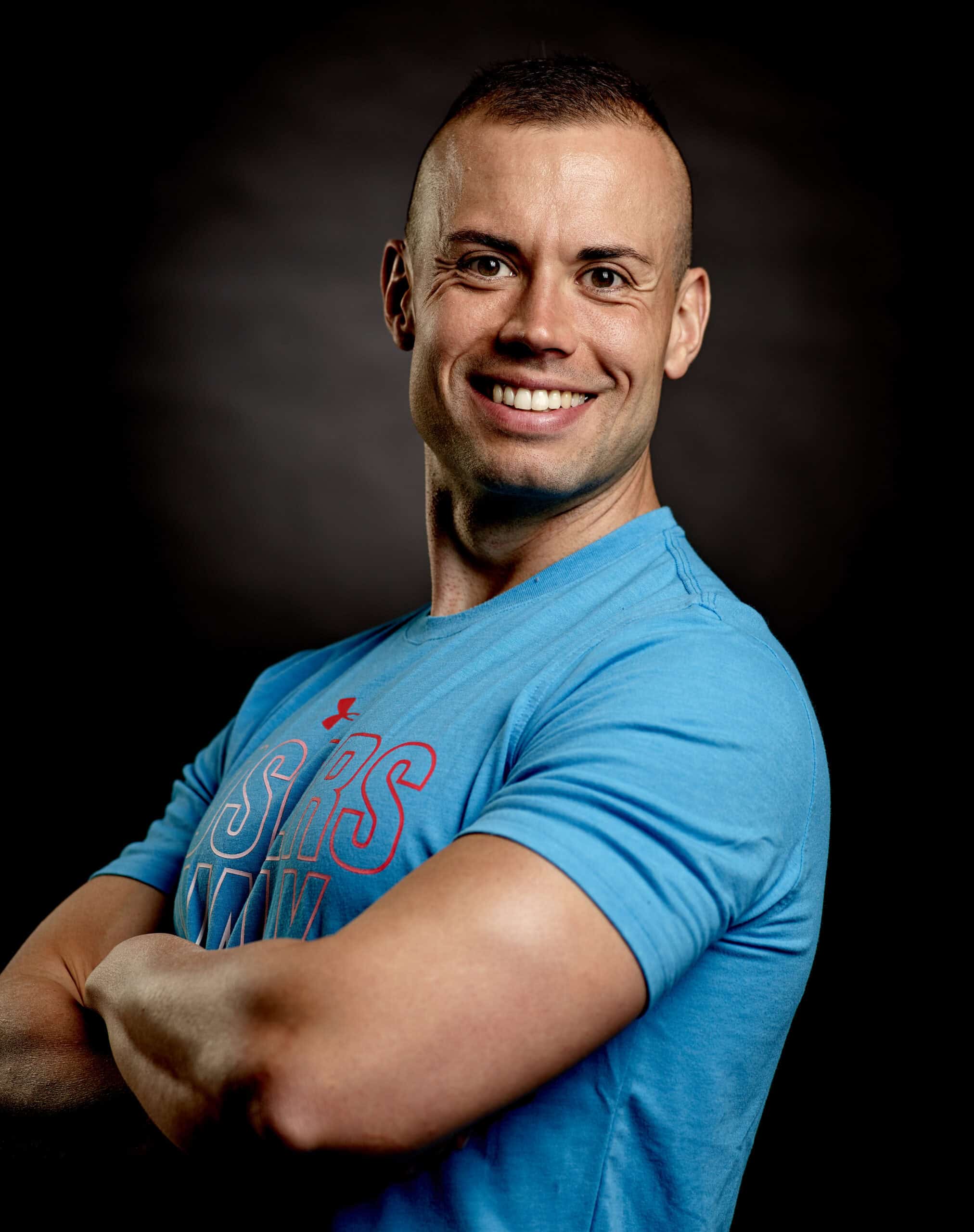 Olaf Henning lächelt in die Kamera und trägt ein blaues Sportshirt.